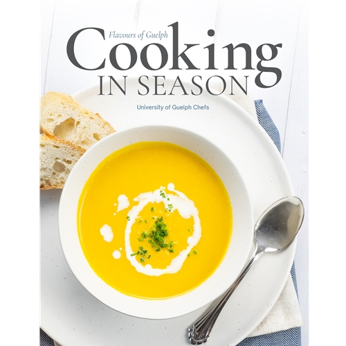 The cover of the Cooking in Season cookbook, featuring a yellow soup.