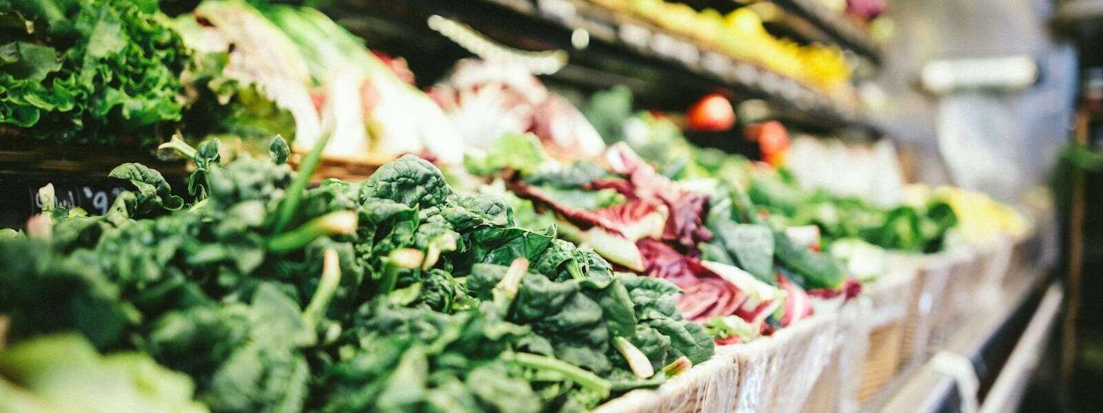 row of vegetables placed on multilayered display fridge