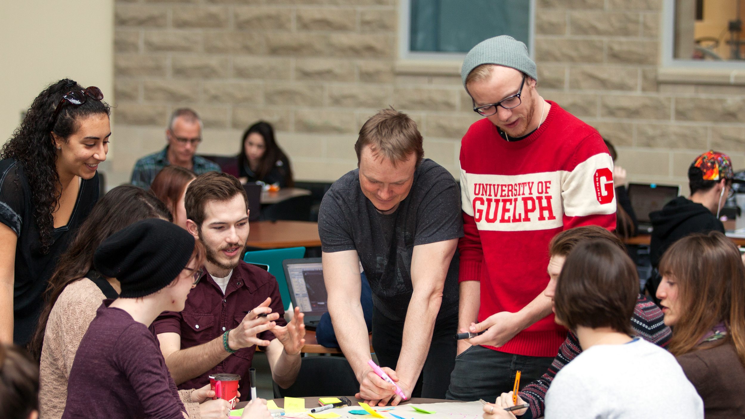 Evan Fraser with several students working over a table