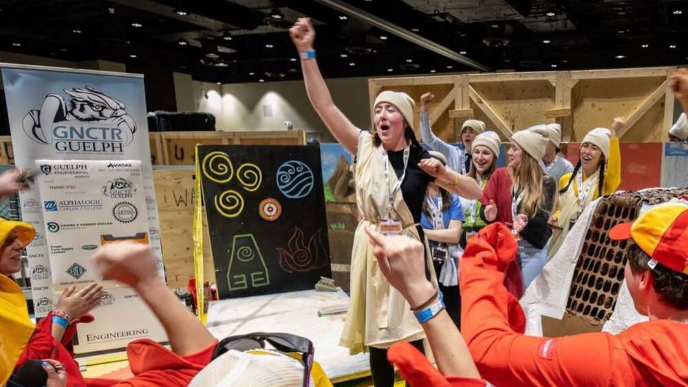 students dressed in costumes perform at an event, there are icons on a black poster board