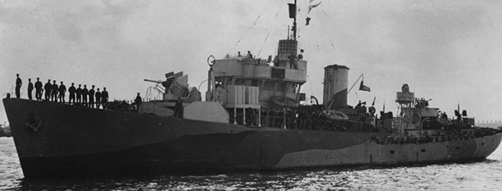 a historical image of a war ship in the water in black and white, with a group of sailors standing on the deck
