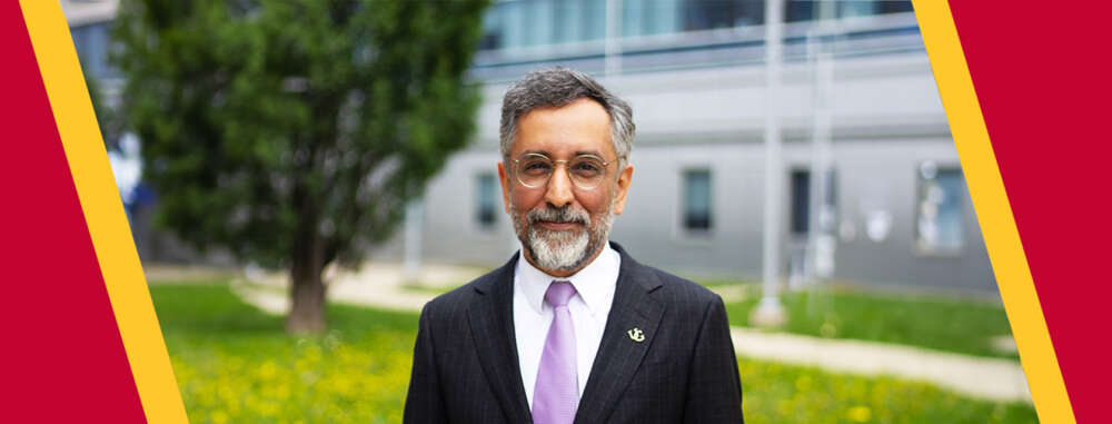 A man with a beard in a suit poses outdoors