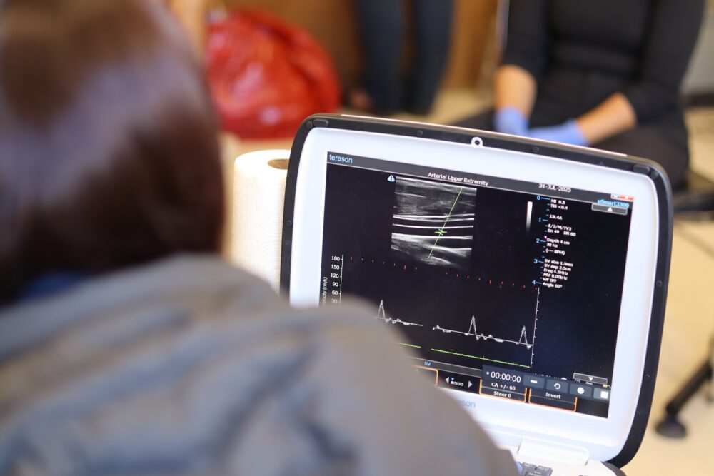 A researcher sits in front of a mobile computer reading stats from tests.