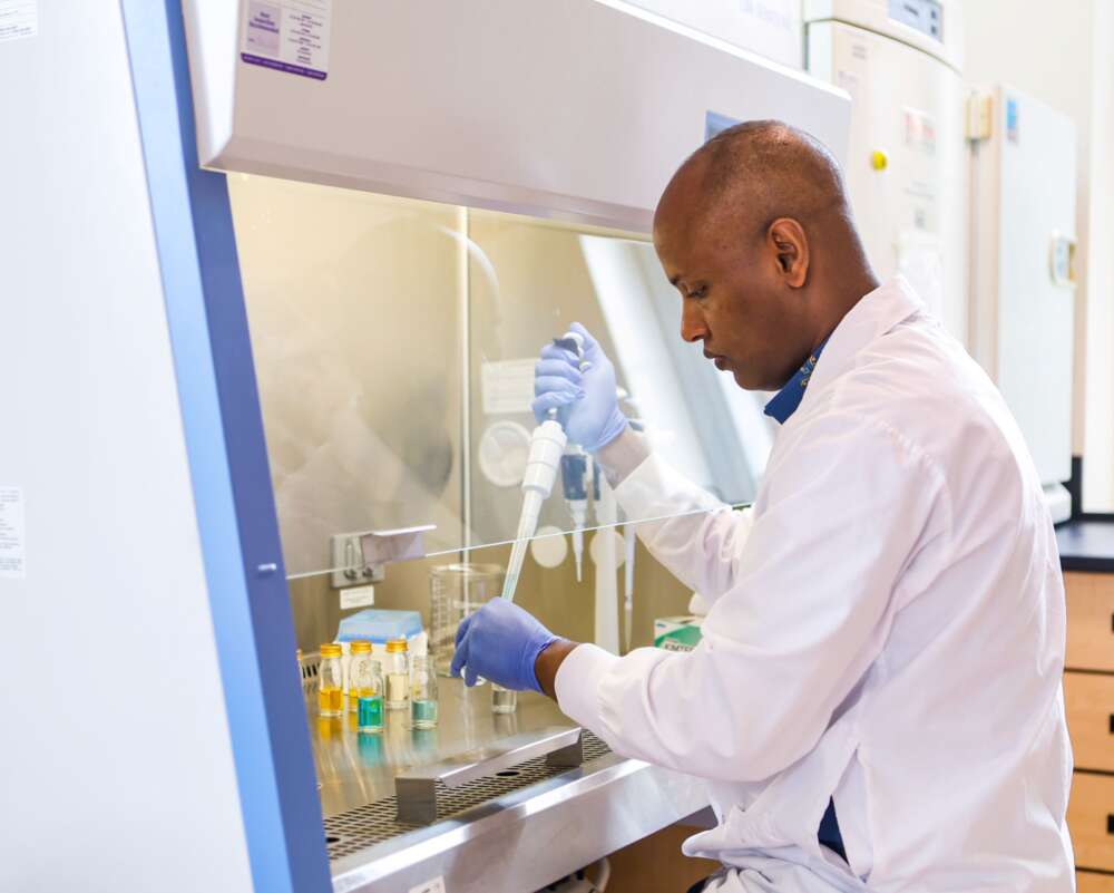 a man conducts tests using an eyedropper and sample bottles in a lab