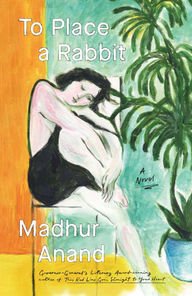 Cover of the novel To Place a Rabbit by Madhur Anand. The artwork is a stylized painting of a woman with pale skin and short dark hair wearing a black slip dress. She sits curled up with her arms around her knees, resting her cheek on them, her eyes closed as if in thought or sleep. Behind her is a tall green potted plant with long leaves against a cool teal background. The left side of the image has bold orange and yellow vertical color blocks. The title appears in large white text across the top: To Place a Rabbit. Below, the author’s name is written in white: Madhur Anand. A handwritten note in yellow reads: “Governor General’s Literary Award-winning author of This Red Line Goes Straight to Your Heart.” The words “A Novel” are written near the woman’s feet.
