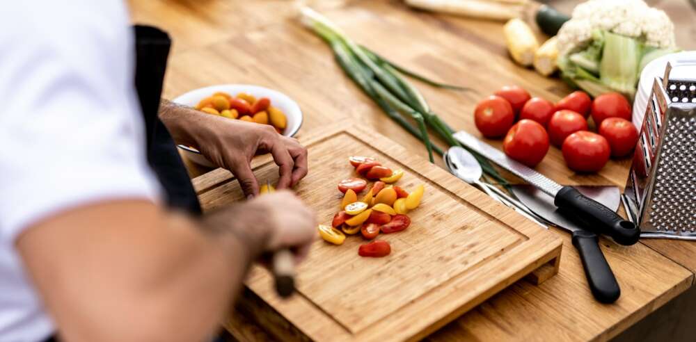 a person cutting up vegetables on a cutting board
