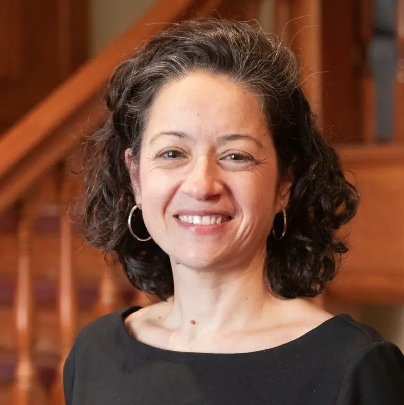 a person in a black shirt poses for a headshot