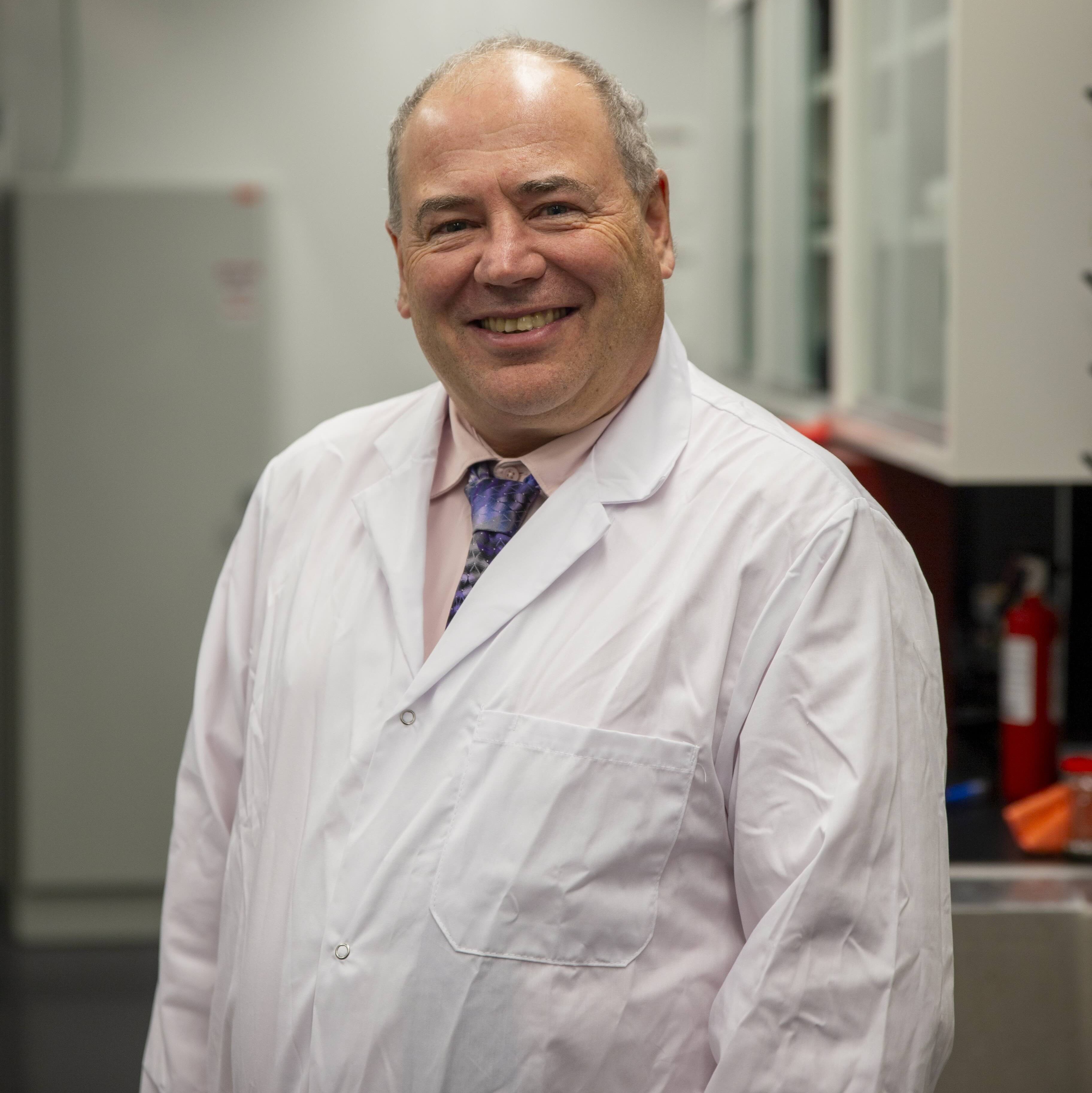 Dr. Kevin Keener in lab coat smiles in bright laboratory