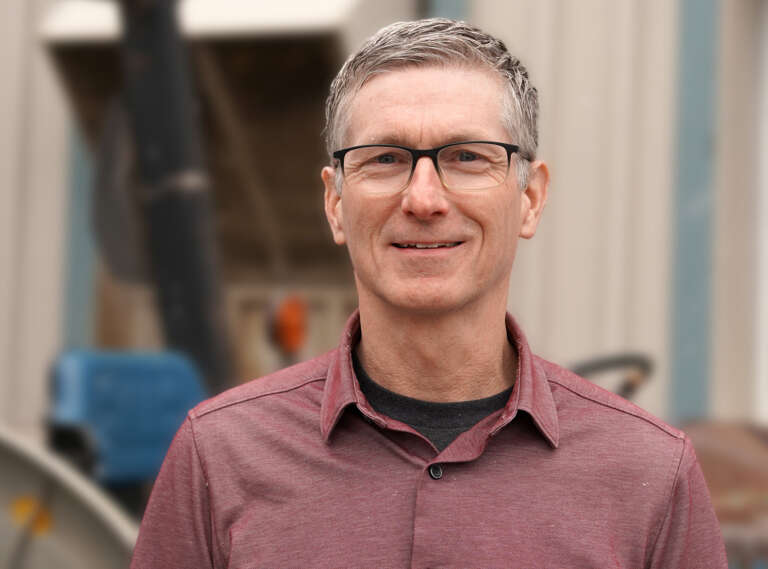 Dr. Derek Haley poses for a photo outside near a barn