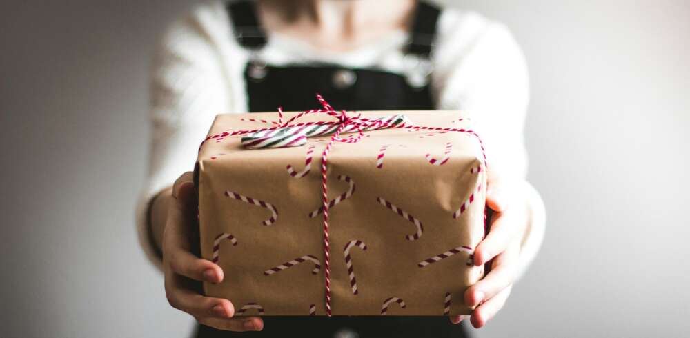 person showing brown gift box
