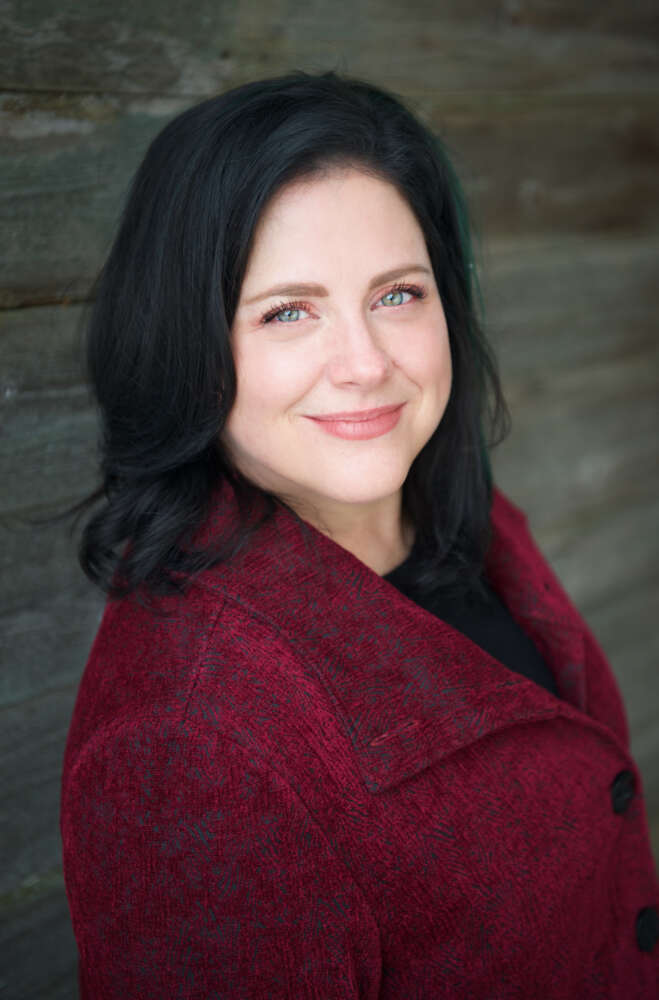 a person in a red jacket poses for a head shot