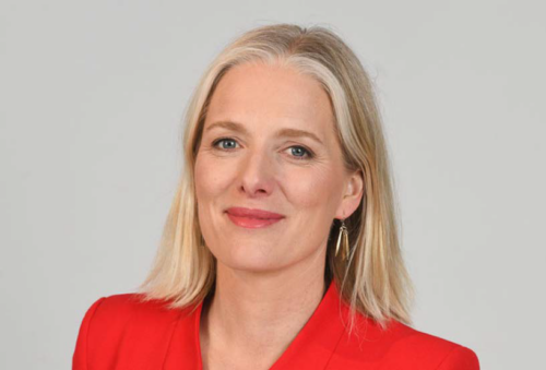 Headshot of Catherine McKenna. Smiling at the camera wearing a red top.