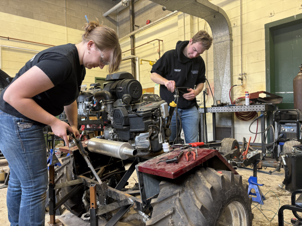 people work on a tractor in an automotive workshop