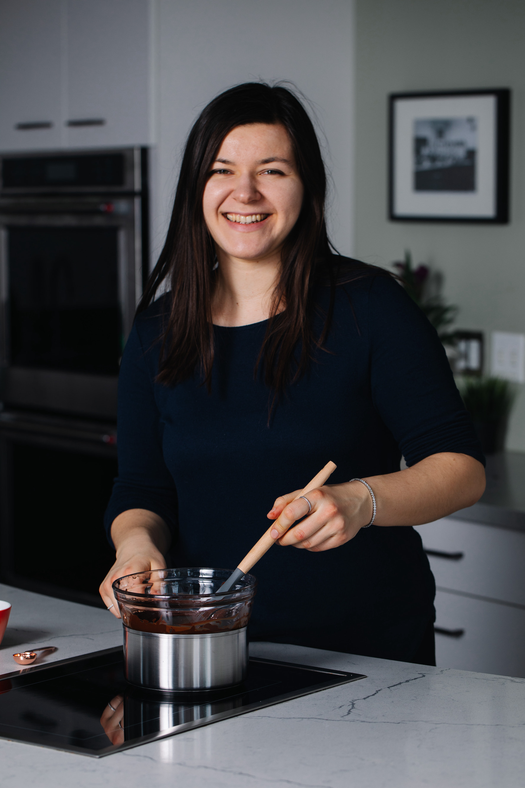 Jessica Ulbikas stands in kitchen stirring a bowl of chocolate