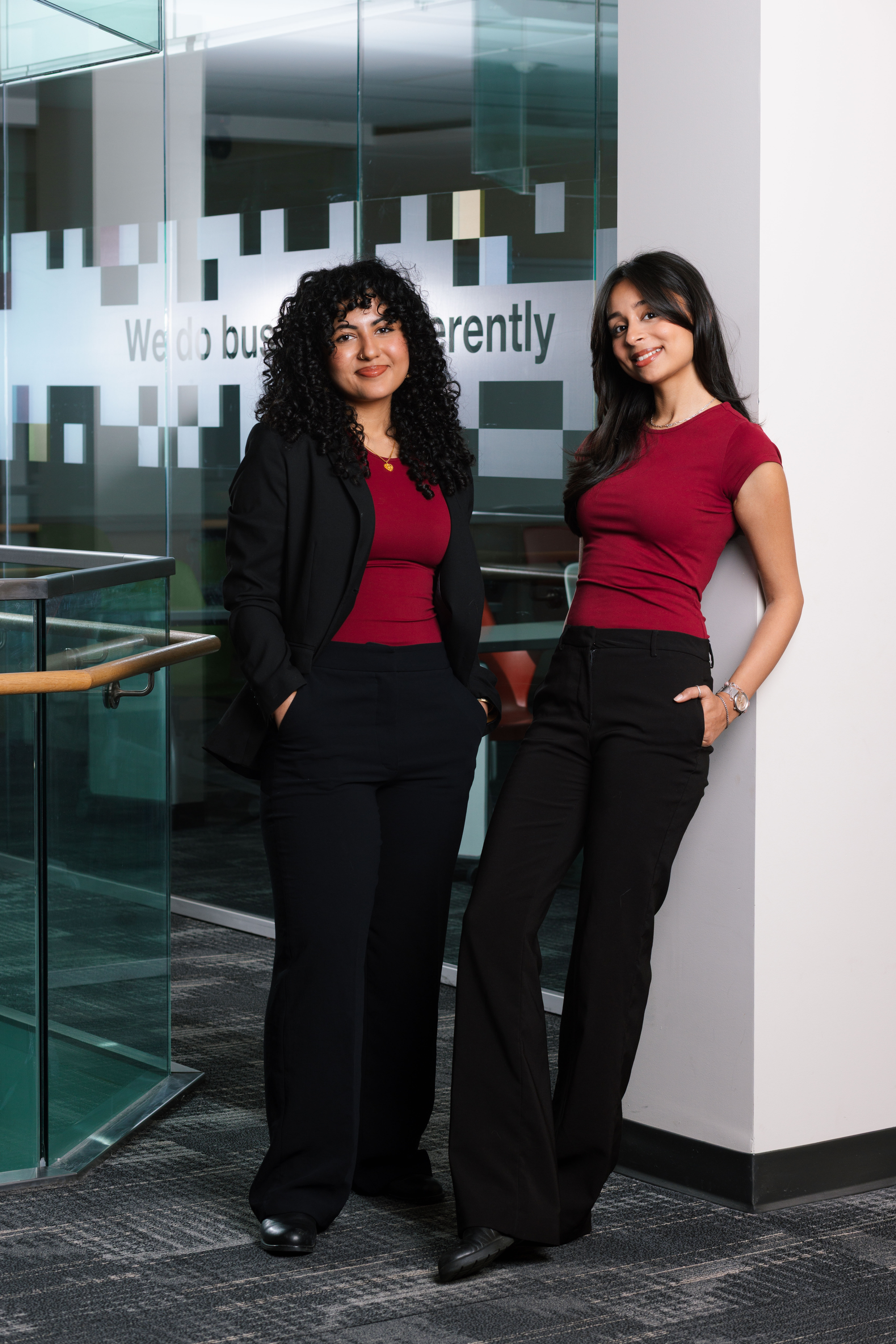Manahil Zaid and Vanya Khanna pose for photo against glass office background