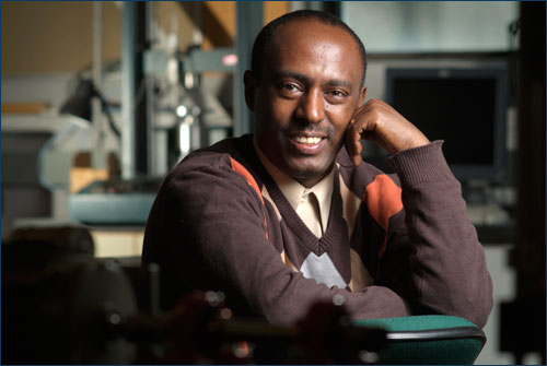 Fantahun Defersha sits wearing a warm brown sweater in a laboratory setting, smiling casually