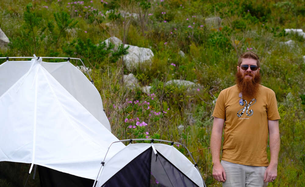person poses next to a tent structure