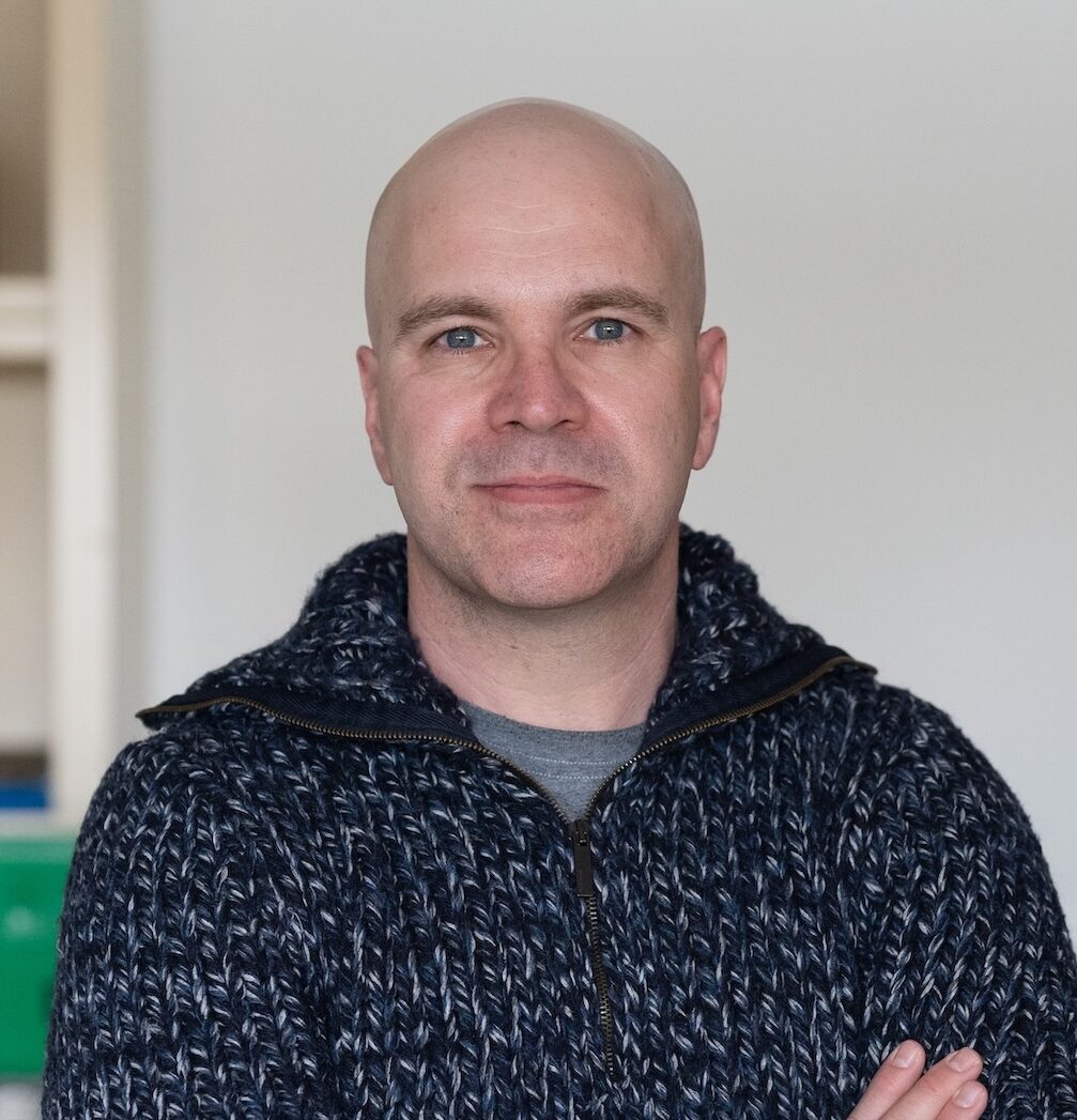 A person crosses their arms while posing for a photo
