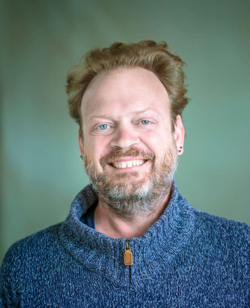 a portrait of a smiling person in a sweater