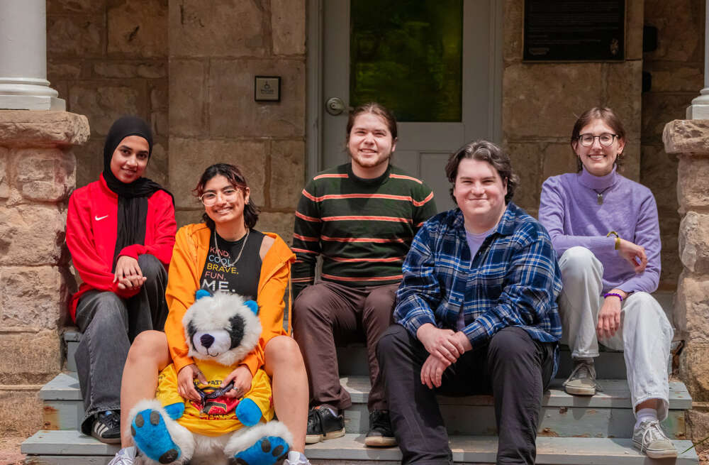 five people pose for a group photo