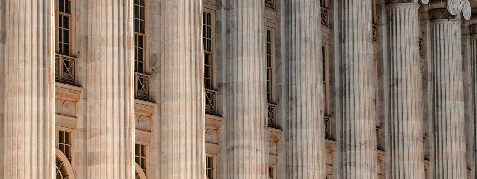 a large building with columns and a clock on the front of it