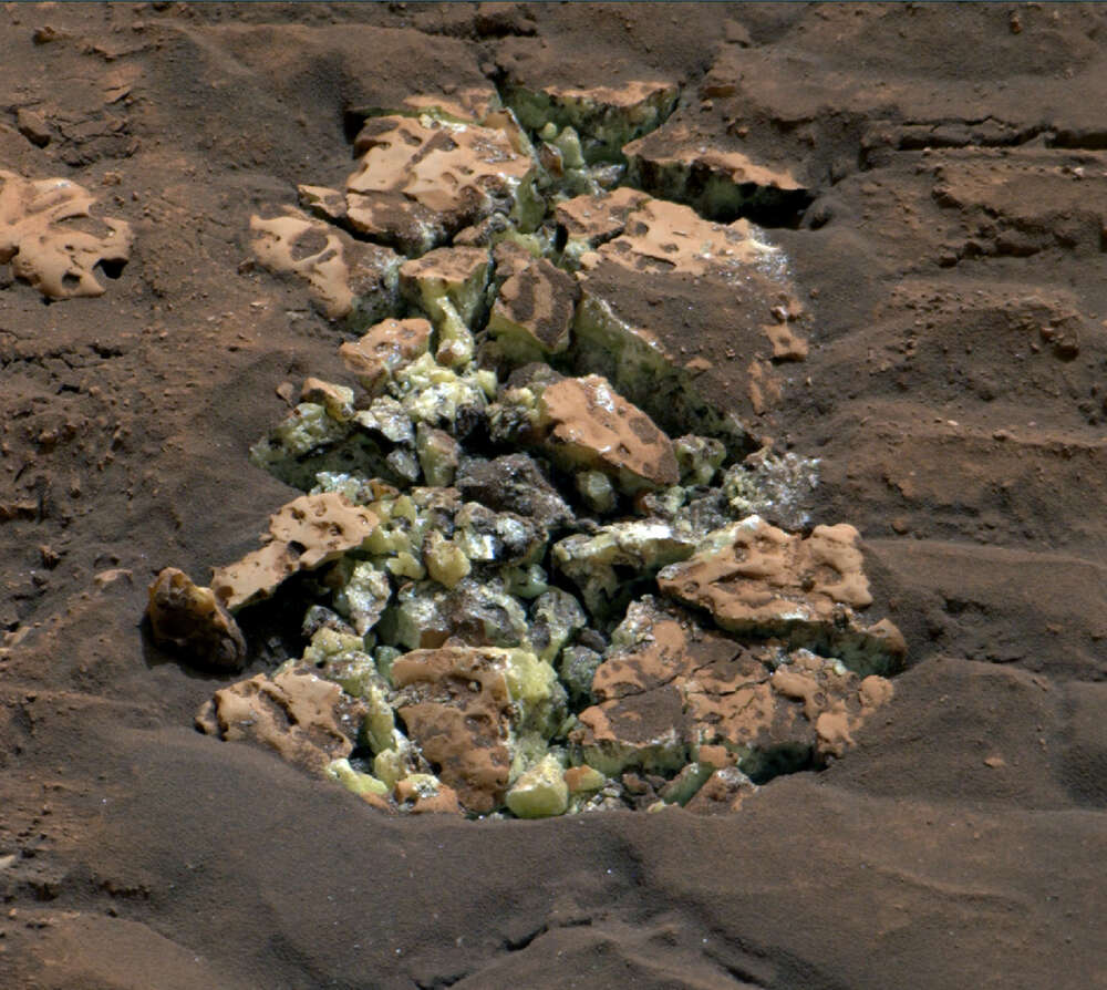 yellow-green crystals among rock and dirt on the Mars surface