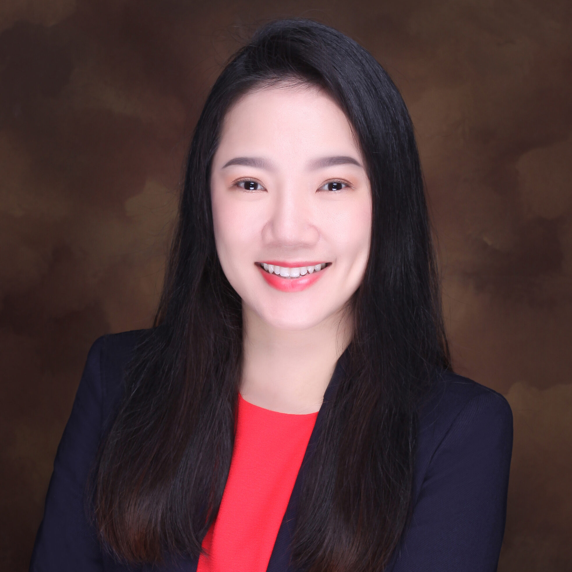 person with long hair in blazer poses for headshot