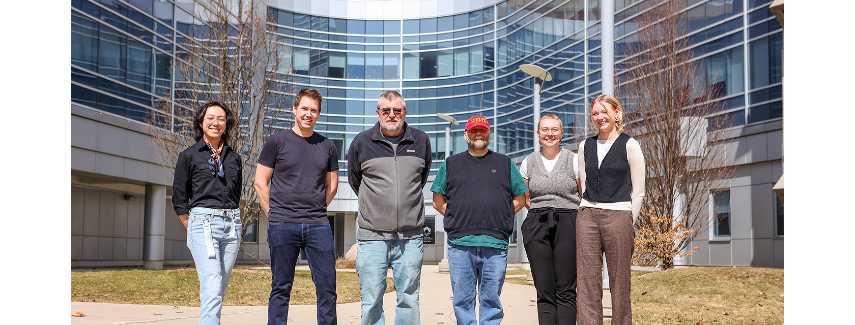six people stand in a row for a photo outside the Summerlee Science Complex