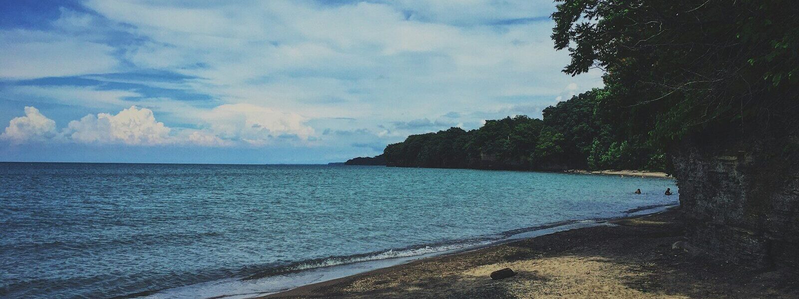 body of water under blue and white sky at daytime