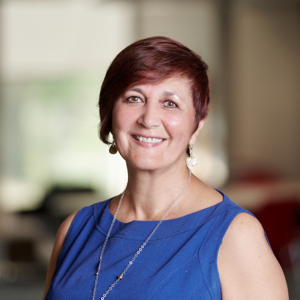 person in blue shirt with short hair poses for headshot
