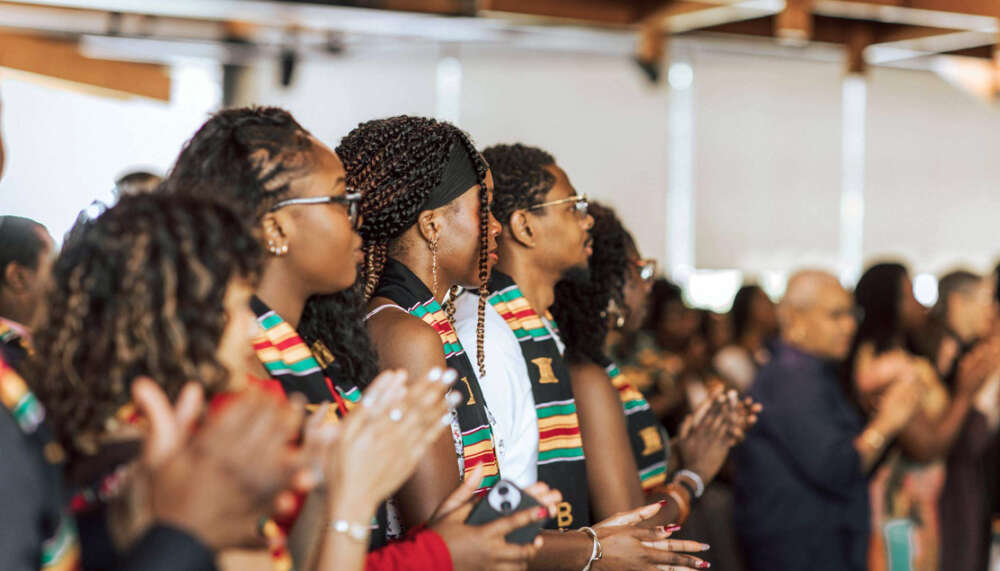 a candid shot of people applauding at a graduation ceremony
