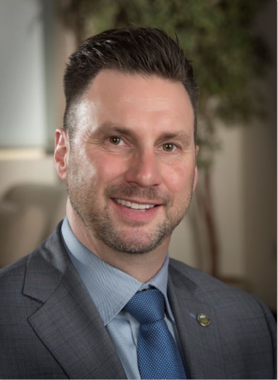 person in suit and tie poses for a headshot