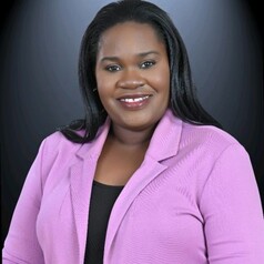 person in pink blazer poses for headshot