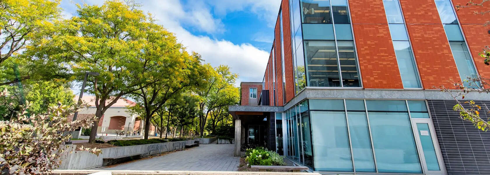 green trees and a glass and red brick building